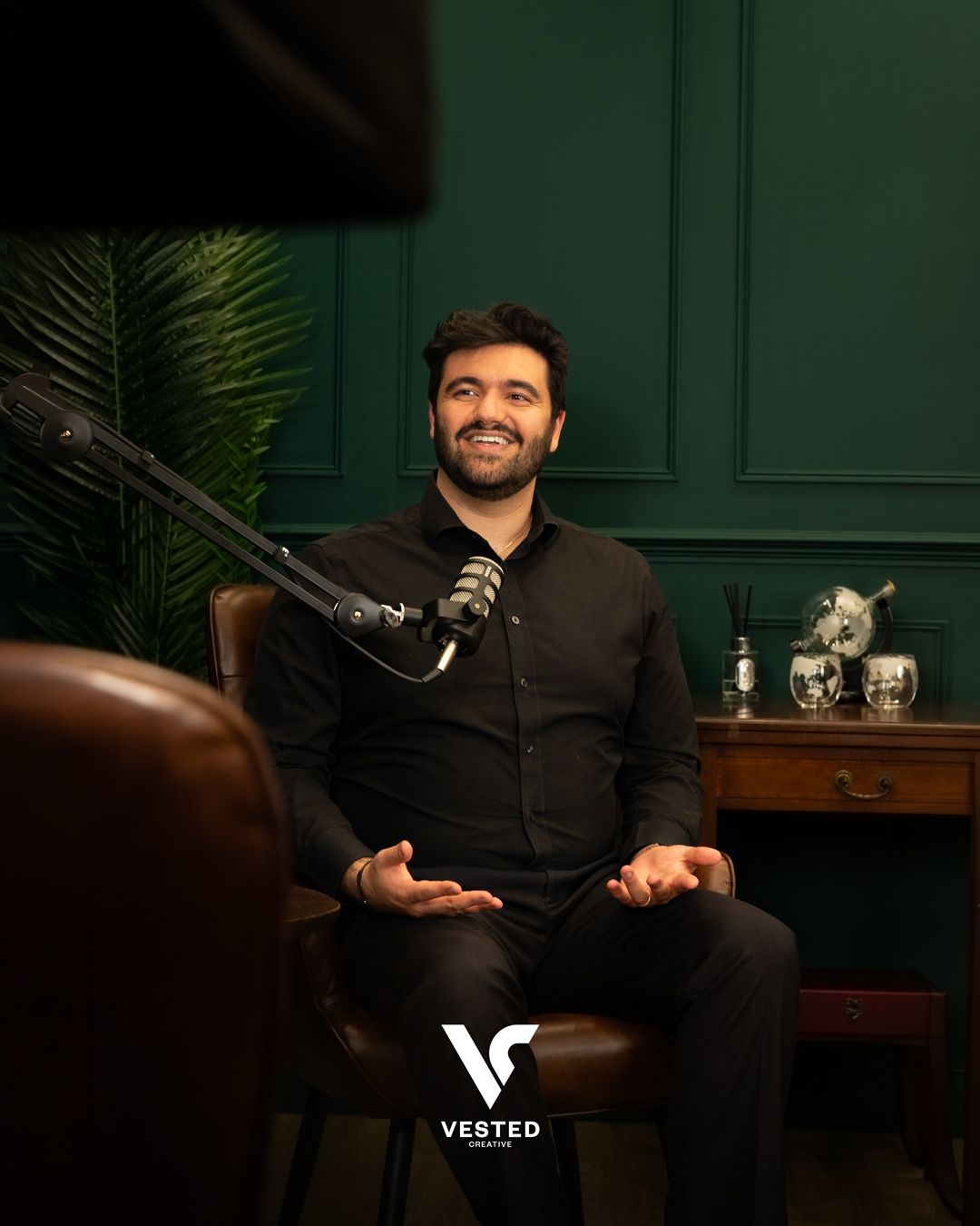 Aaron Godsi seated in the Vested Creative podcast studio
